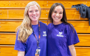  two teachers wearing purple shirts smiling 